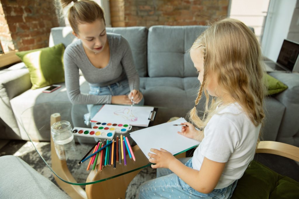 Teacher and little girl, or mom and daughter. Homeschooling concept